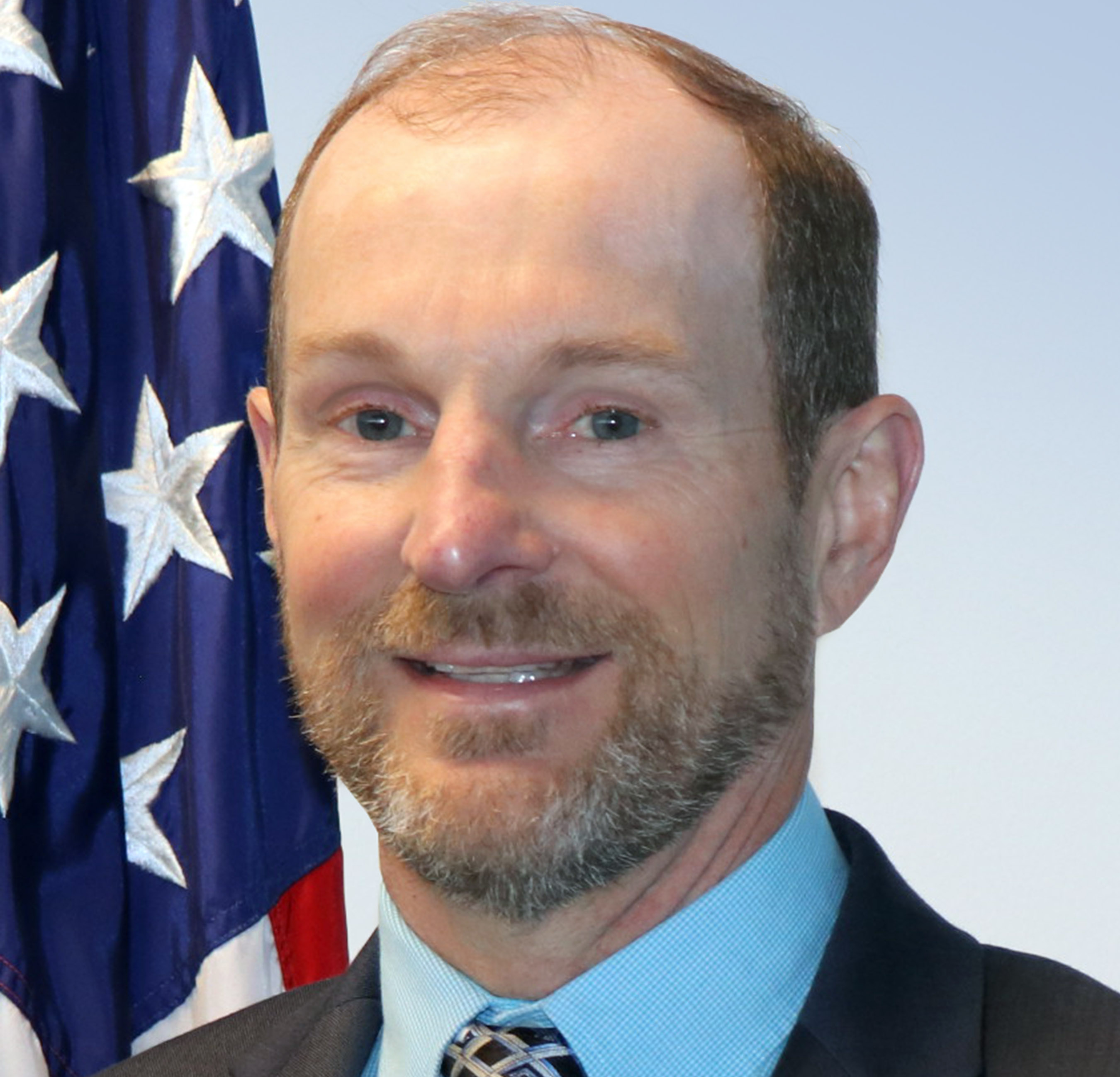 Jeff Privette headshot in front of the US American Flag.