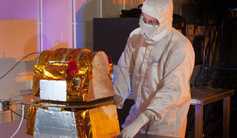An engineer inspects the CERES instrument up close.