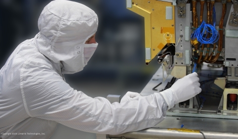Close-up of person in dust suit inspecting CrIS instrument.