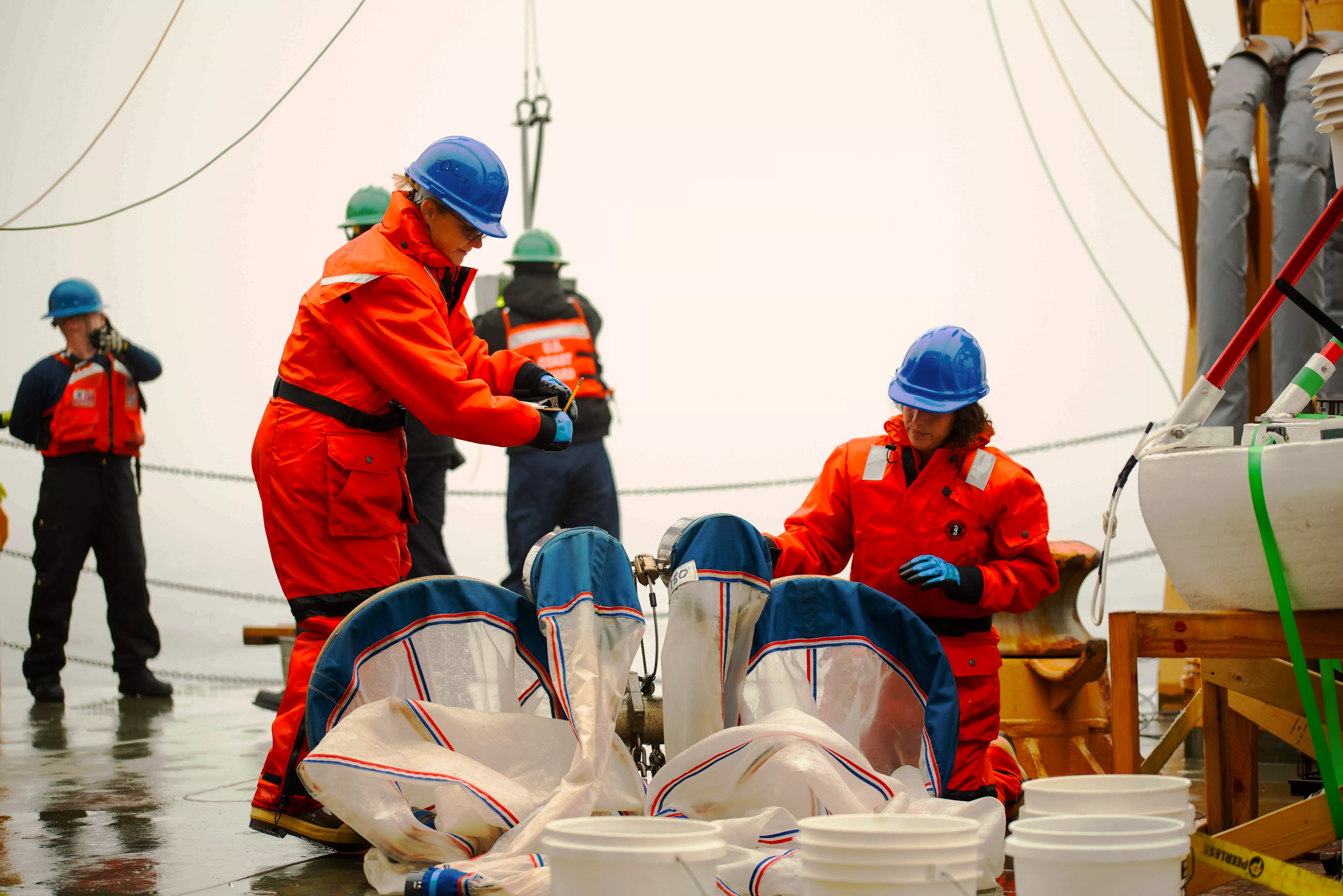 Image of Janet Duffy-Anderson, NOAA EcoFOCI Program Lead, and NOAA Knauss Fellow Chrissy Hayes rinse bongo nets used to collect zooplankton