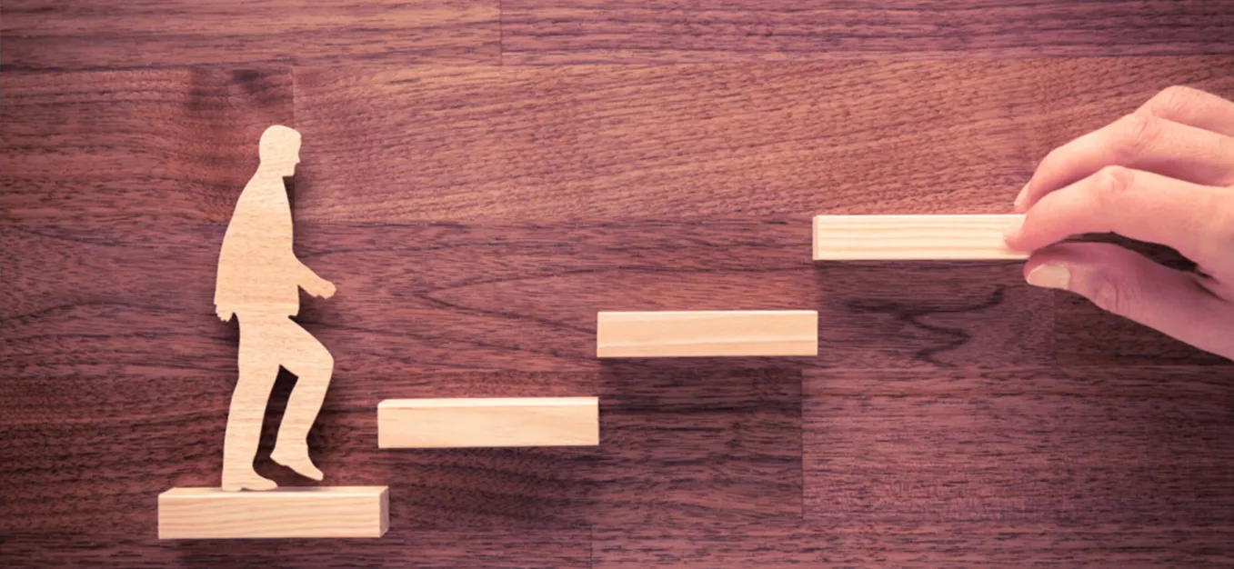 Image of a blocks and wooden person walking up steps