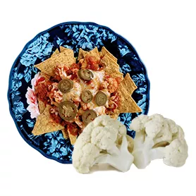 Cauliflower florets in front of a plate with colorful food
