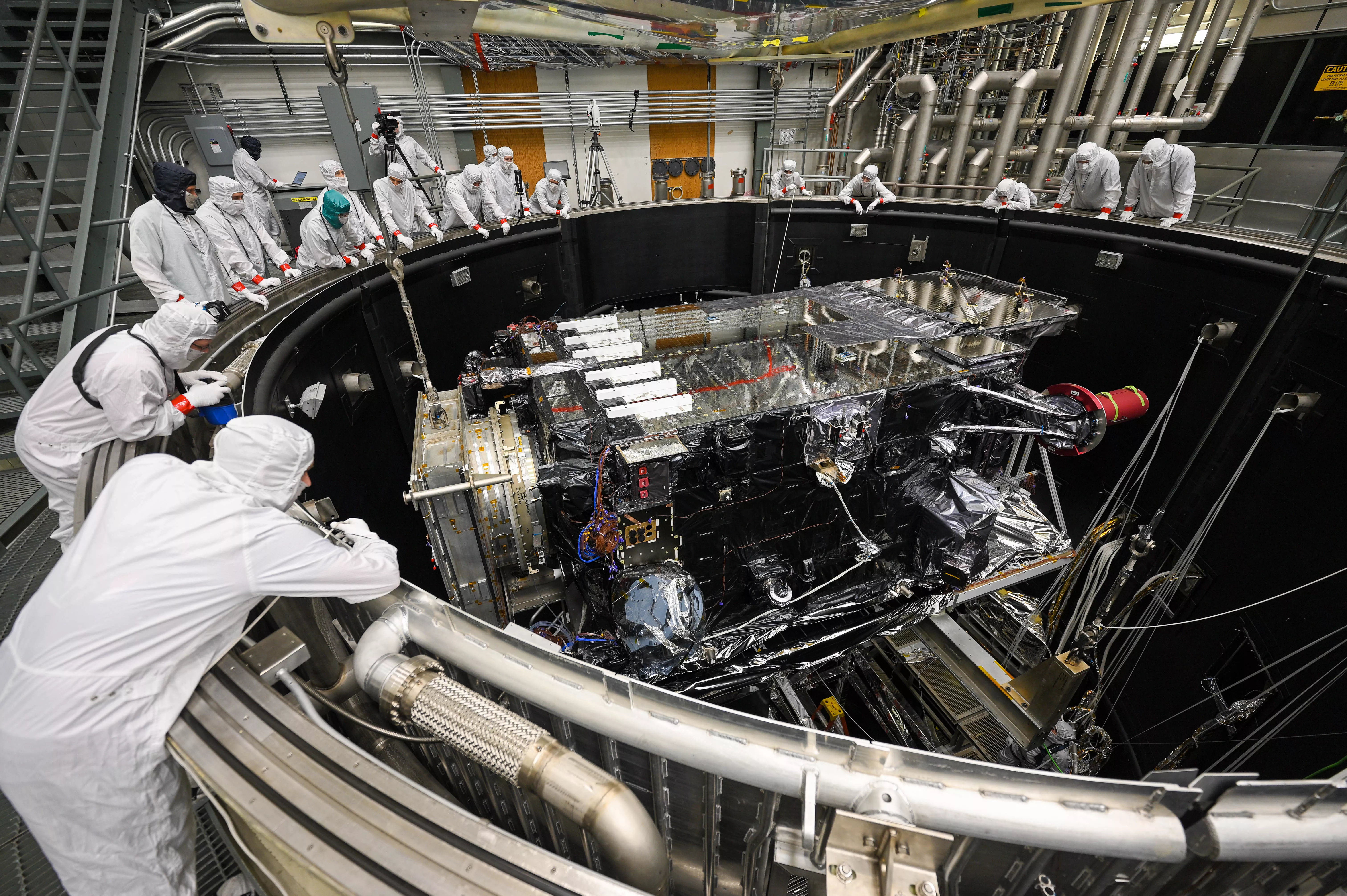 Image of the GOES-U satellite being lowered into the thermal vacuum chamber for testing.