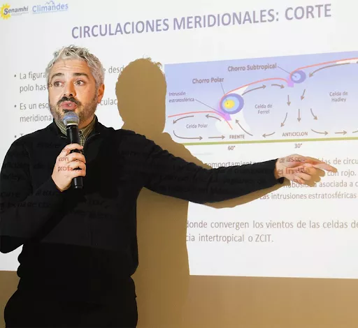 José Manuel Gálvez giving a presentation pointing to a powerpoint on a screen.