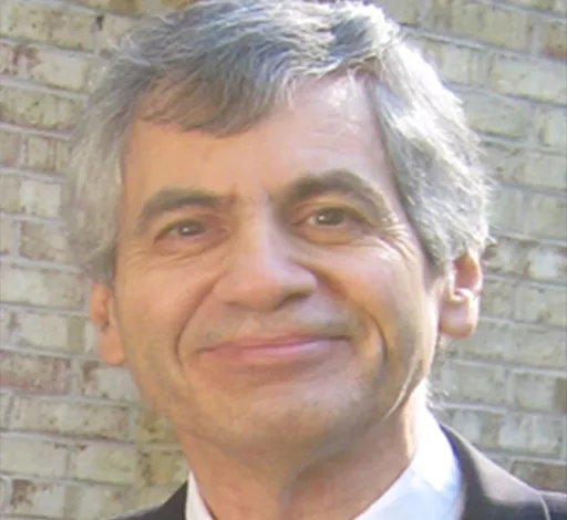 Sheldon Kusselson smiling in front of a wall