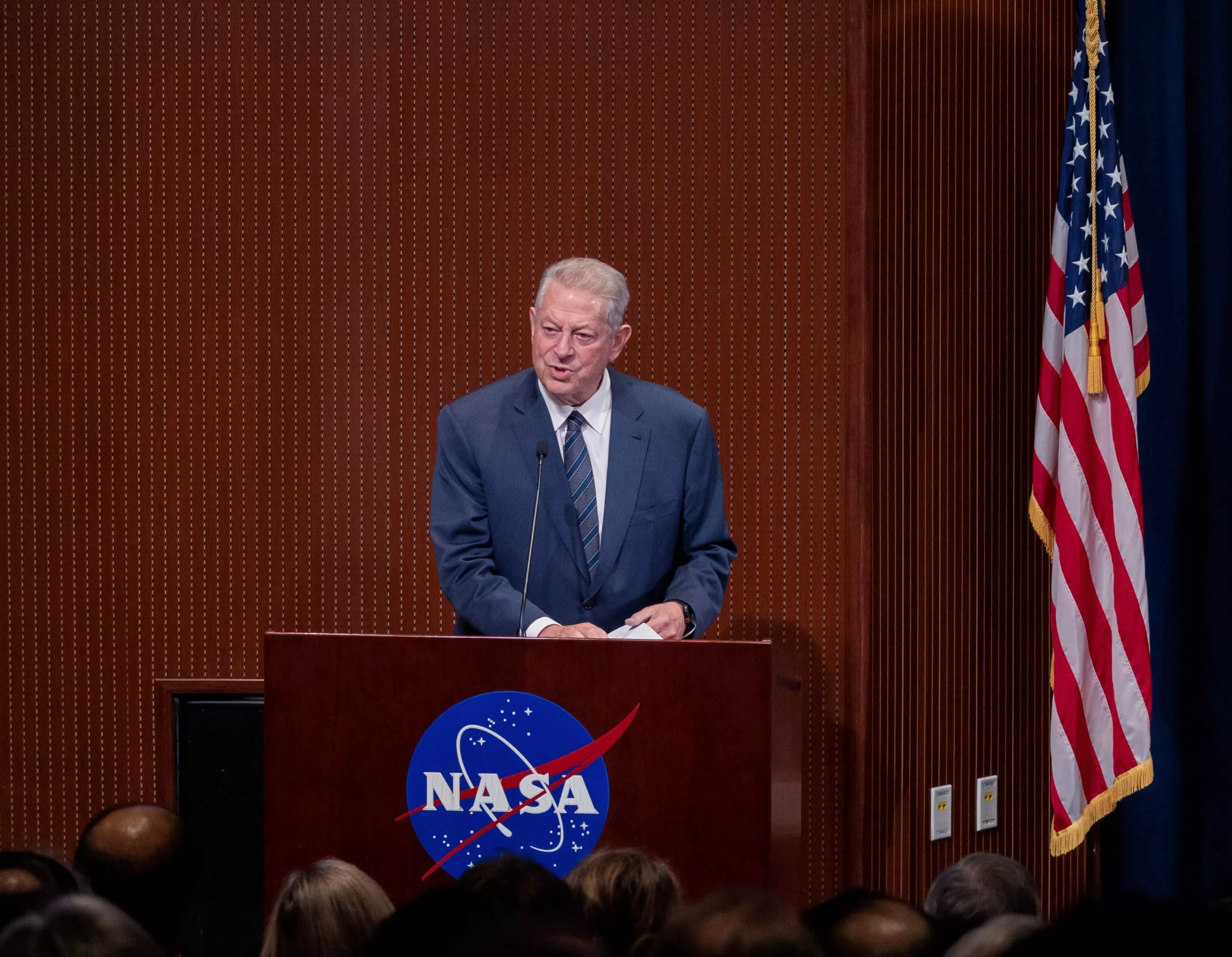 Former Vice President Al Gore speaking at a podium with a NASA logo.