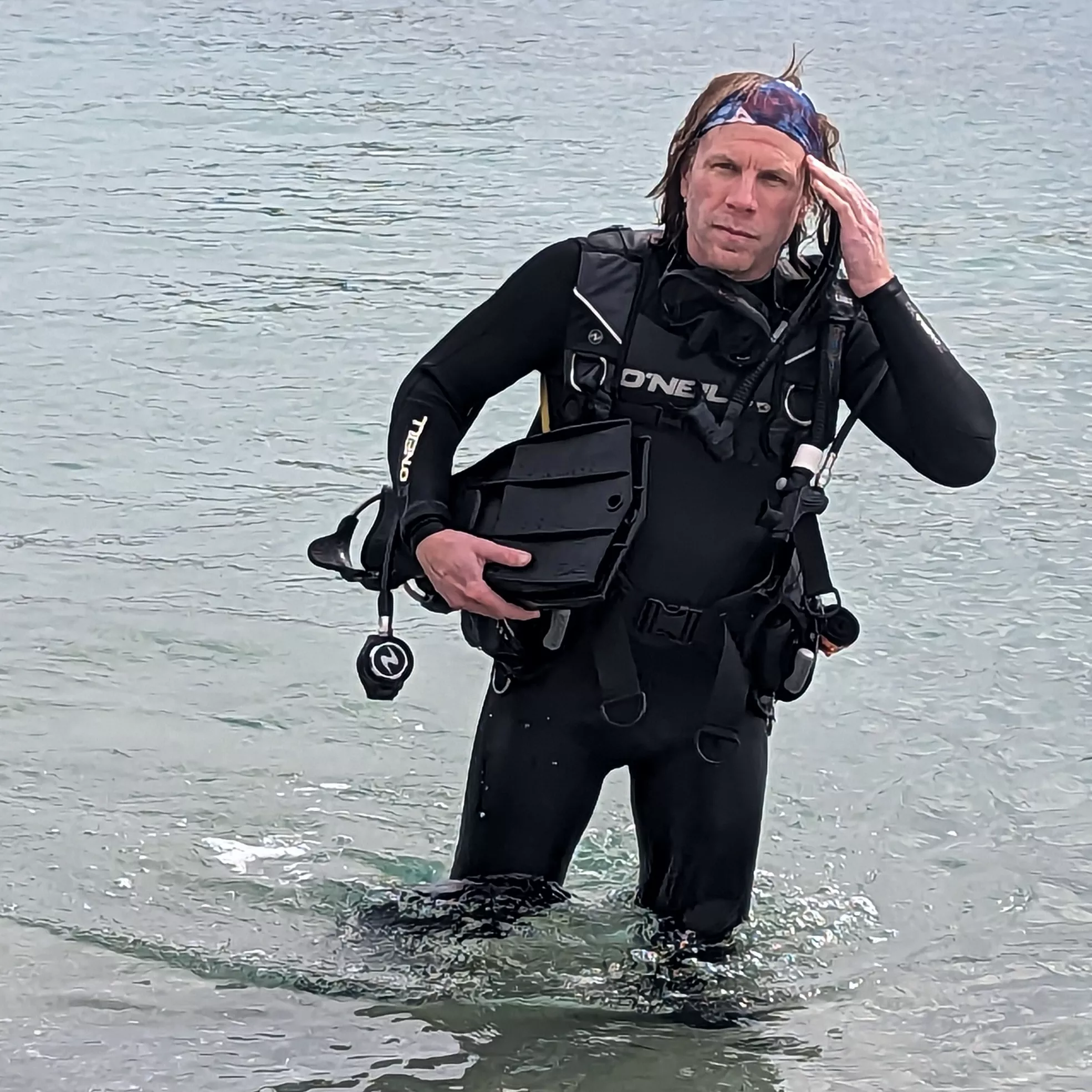Erick Gelmer In a wet suit in the ocean.
