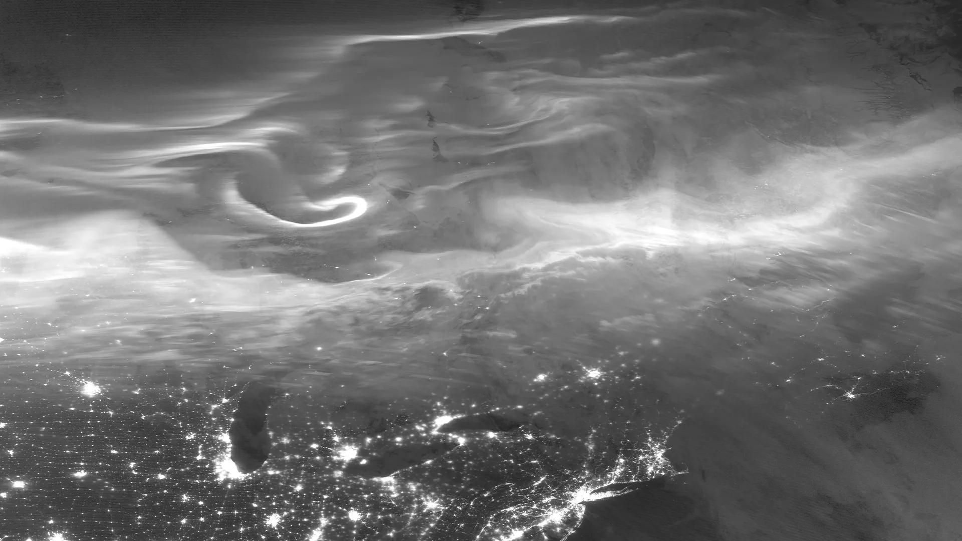 Aurora over North America captured in VIIRS DNB grayscale imagery, with swirling auroral light visible above city lights.
