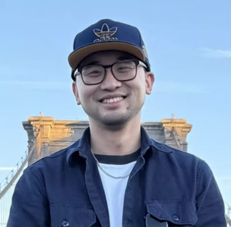 Meng Zhou outside with a blue backgorund.