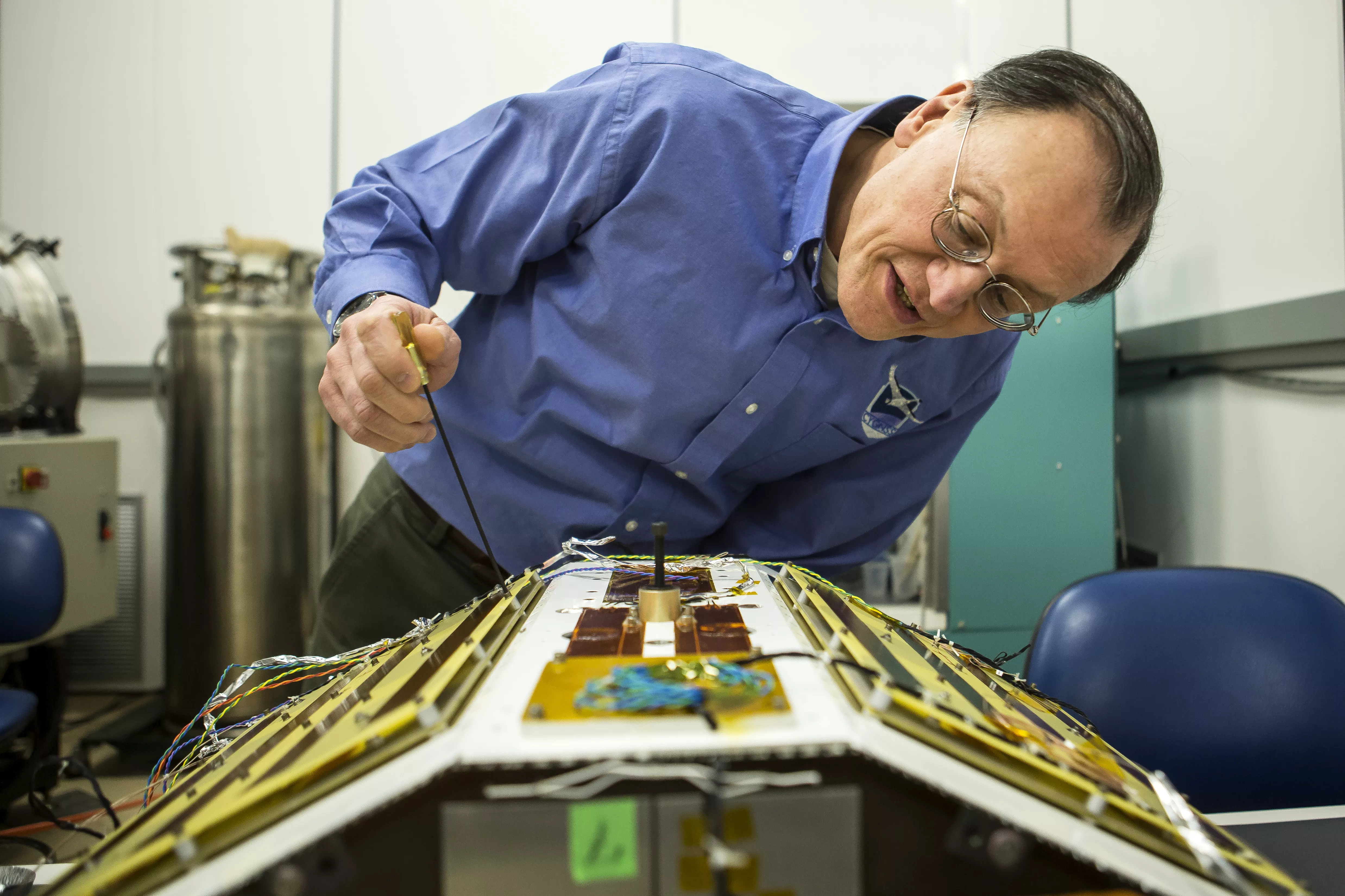 Image of a man working on a satellite